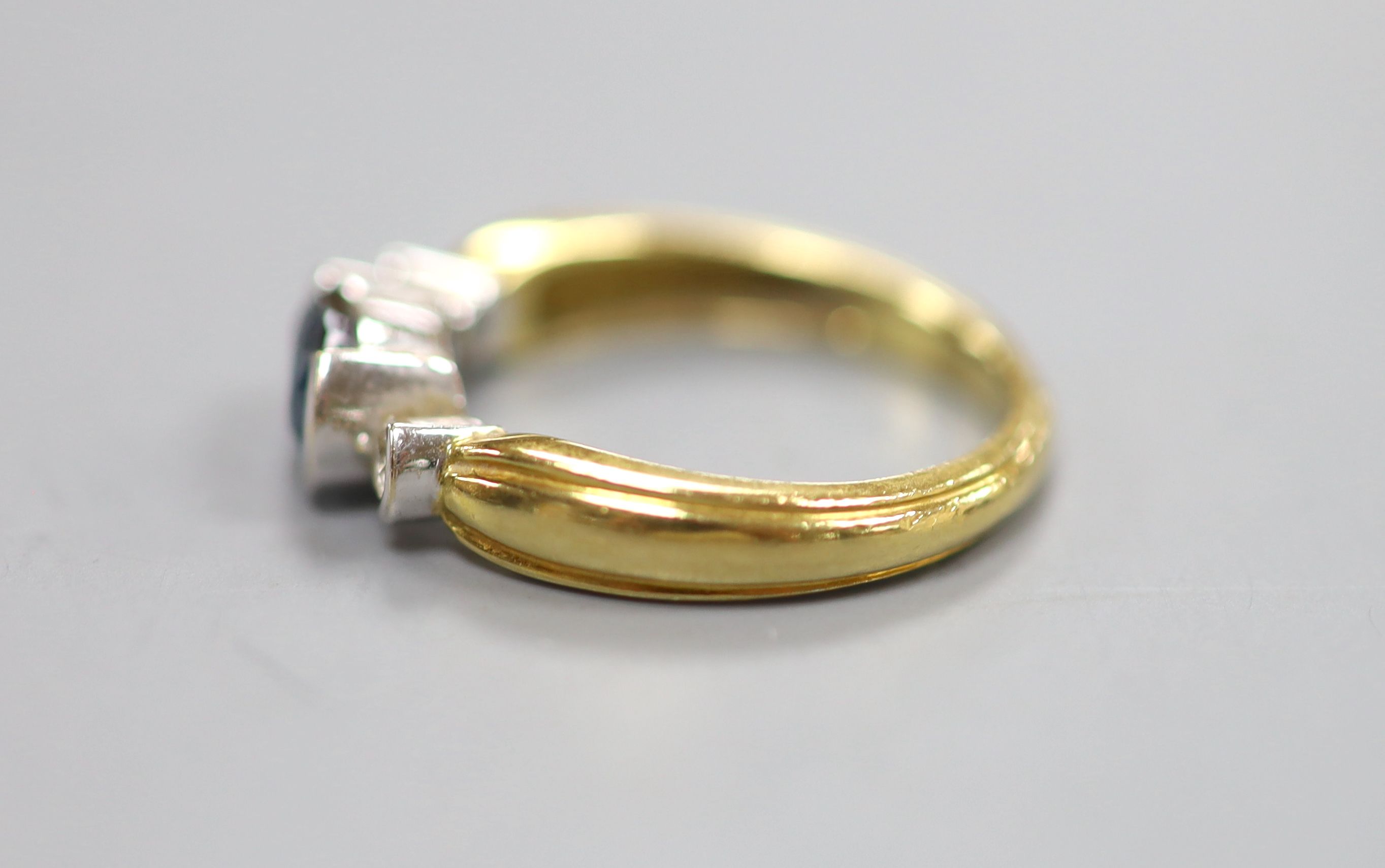 A modern 18ct, sapphire and diamond set three stone ring, size M, gross 4.1 grams.